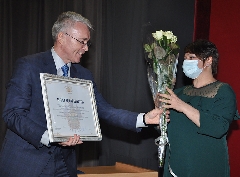 Эдуард Кузнецов вручает награду руководителю библиотеки Родниковского сельского поселения Екатерине Шестаковой